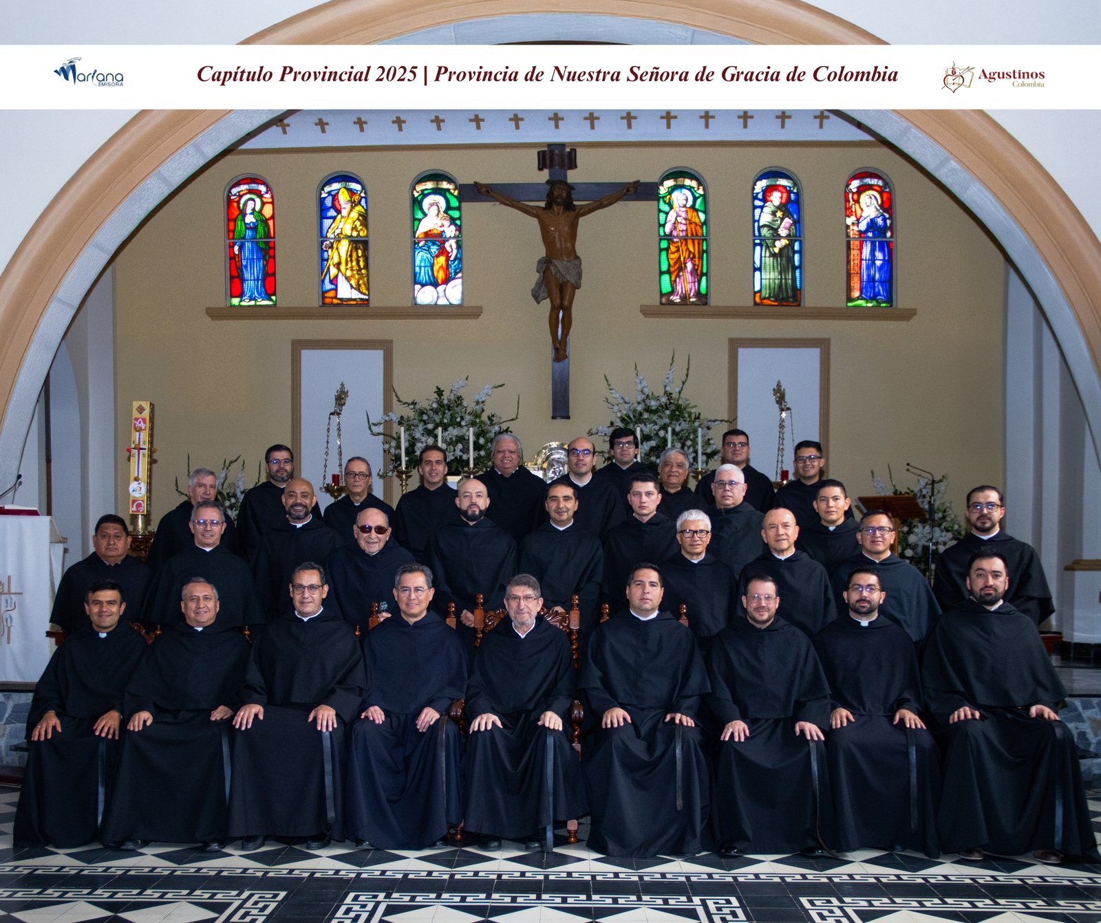 Foto grupal del Consejo Provincial de la Provincia de Nuestra Señora de Gracia de la Orden de San Agustín en Colombia, tomada en el interior de una iglesia con un crucifijo y vitrales al fondo.