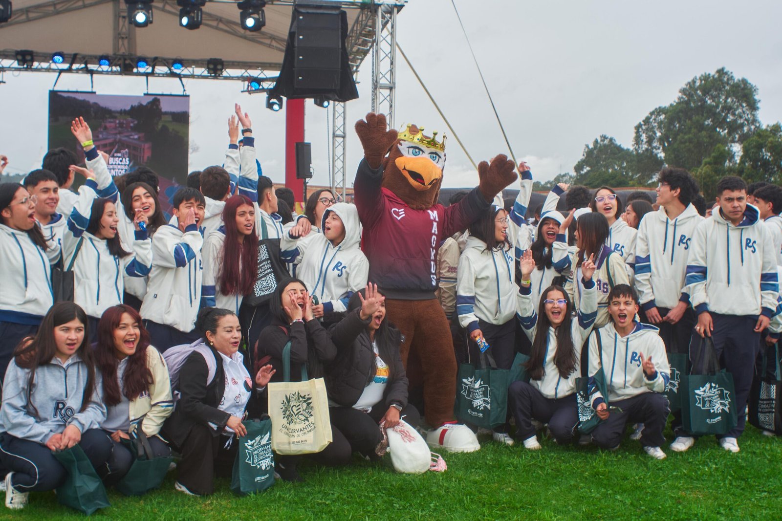 Estudiantes de diferentes colegios posan junto a una mascota universitaria durante el Brunch Fest 2025, un evento educativo con temática medieval que promueve el acceso a la educación superior.