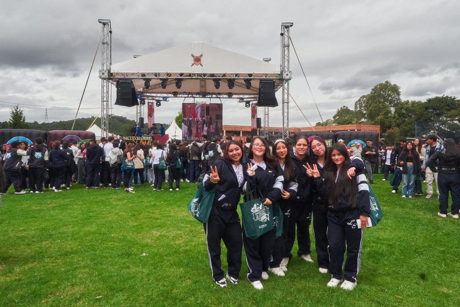 Grupo de estudiantes sonrientes posa frente a la tarima principal del Brunch Fest 2025, en un ambiente al aire libre con actividades, música y participación juvenil.